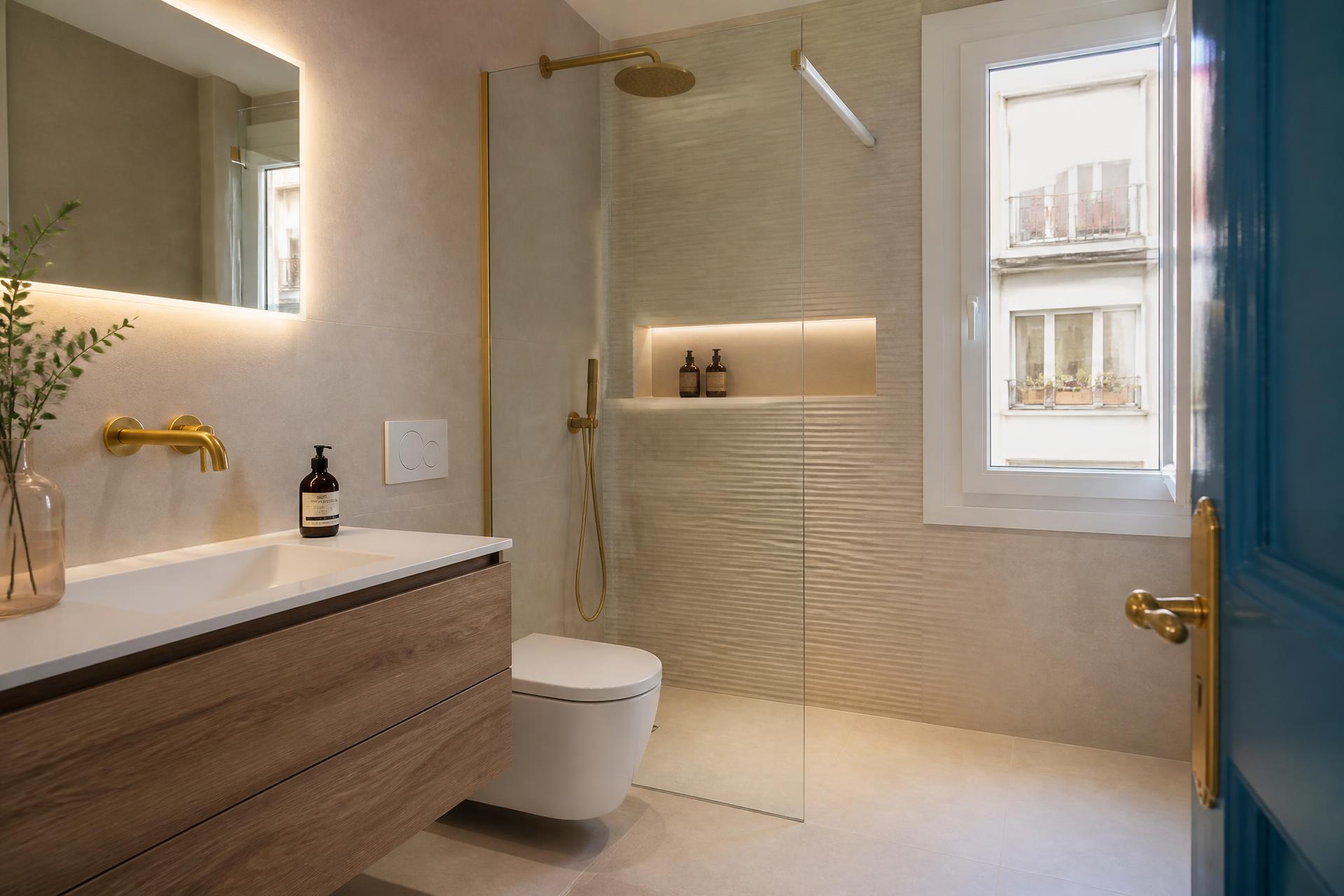 Baño reformado con ducha y revestimiento claro